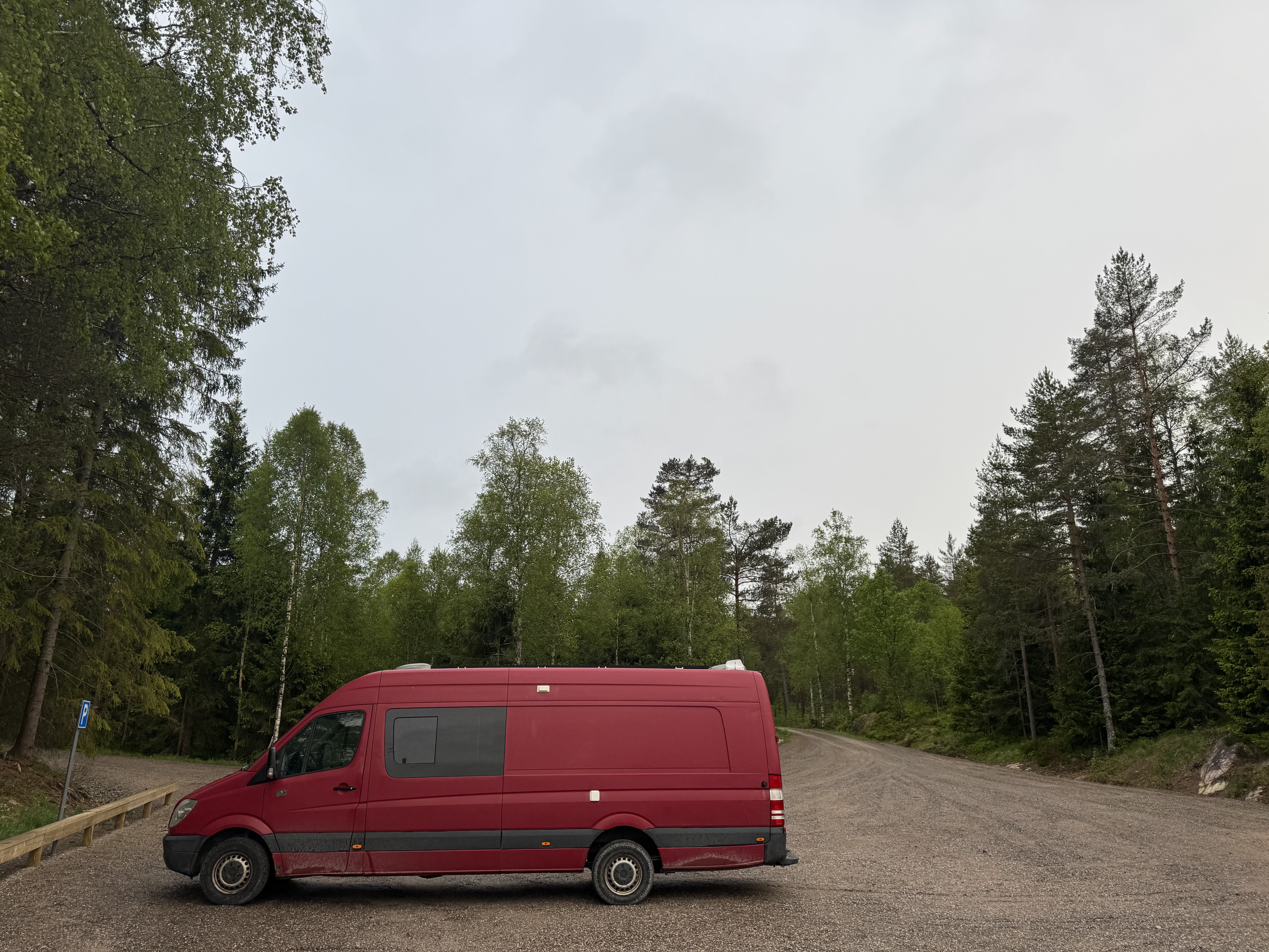 Czerwony sprinter na parkingu lesnym