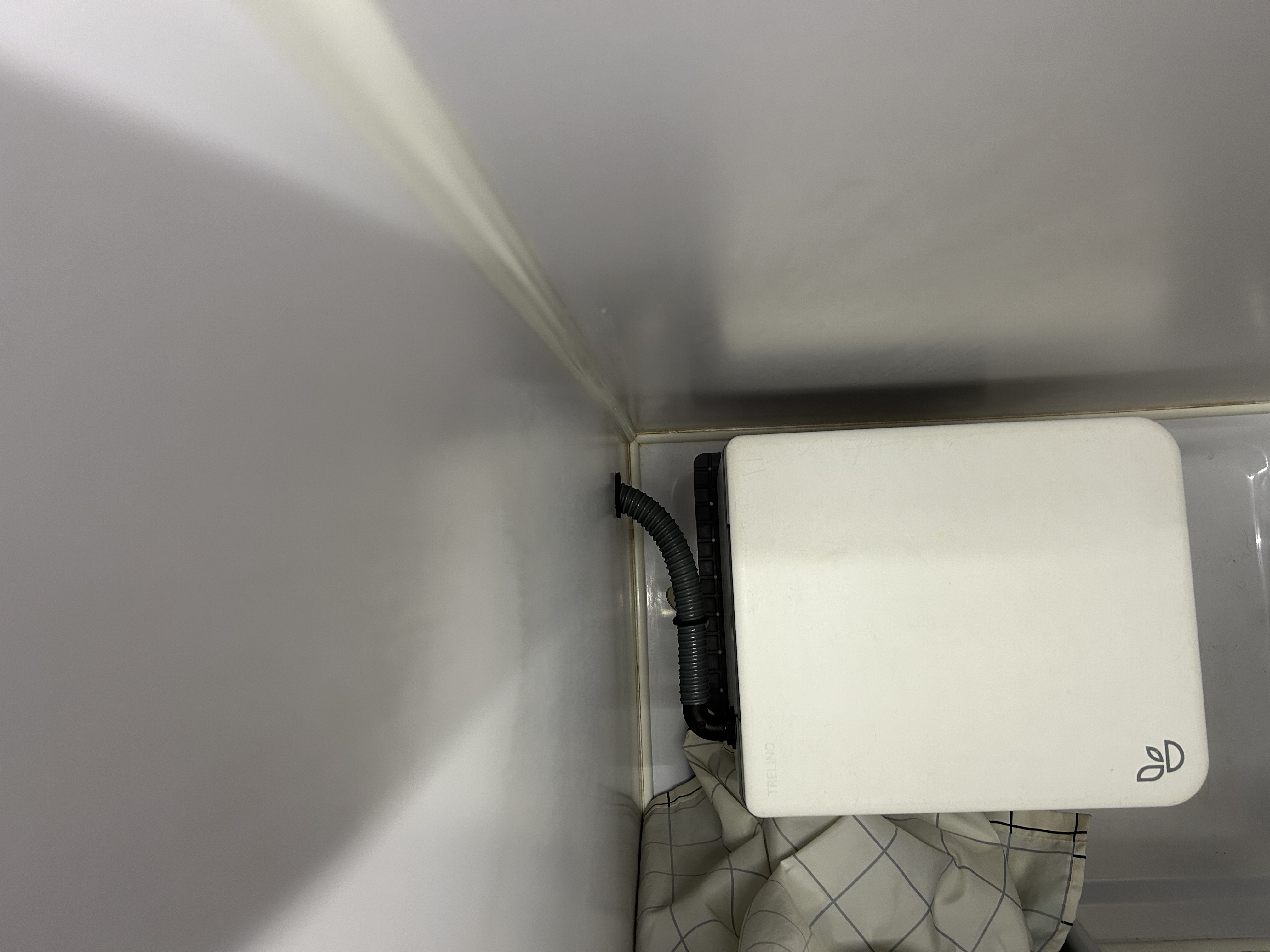 Zdjęcie przyłącza rury wentylatora do toalety separacyjnej w łazience.